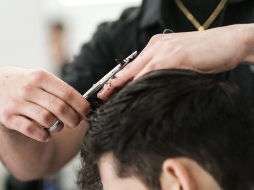young man getting a haircut at mgx barbers Hayward CA