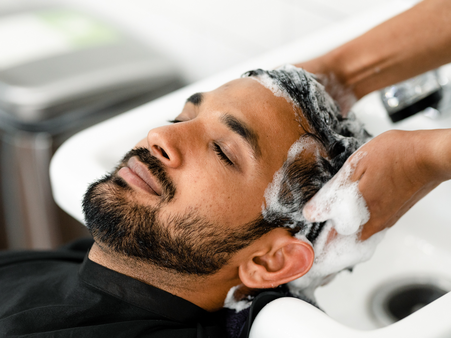 client getting a shampoo at the barber shop | MGX Barbers